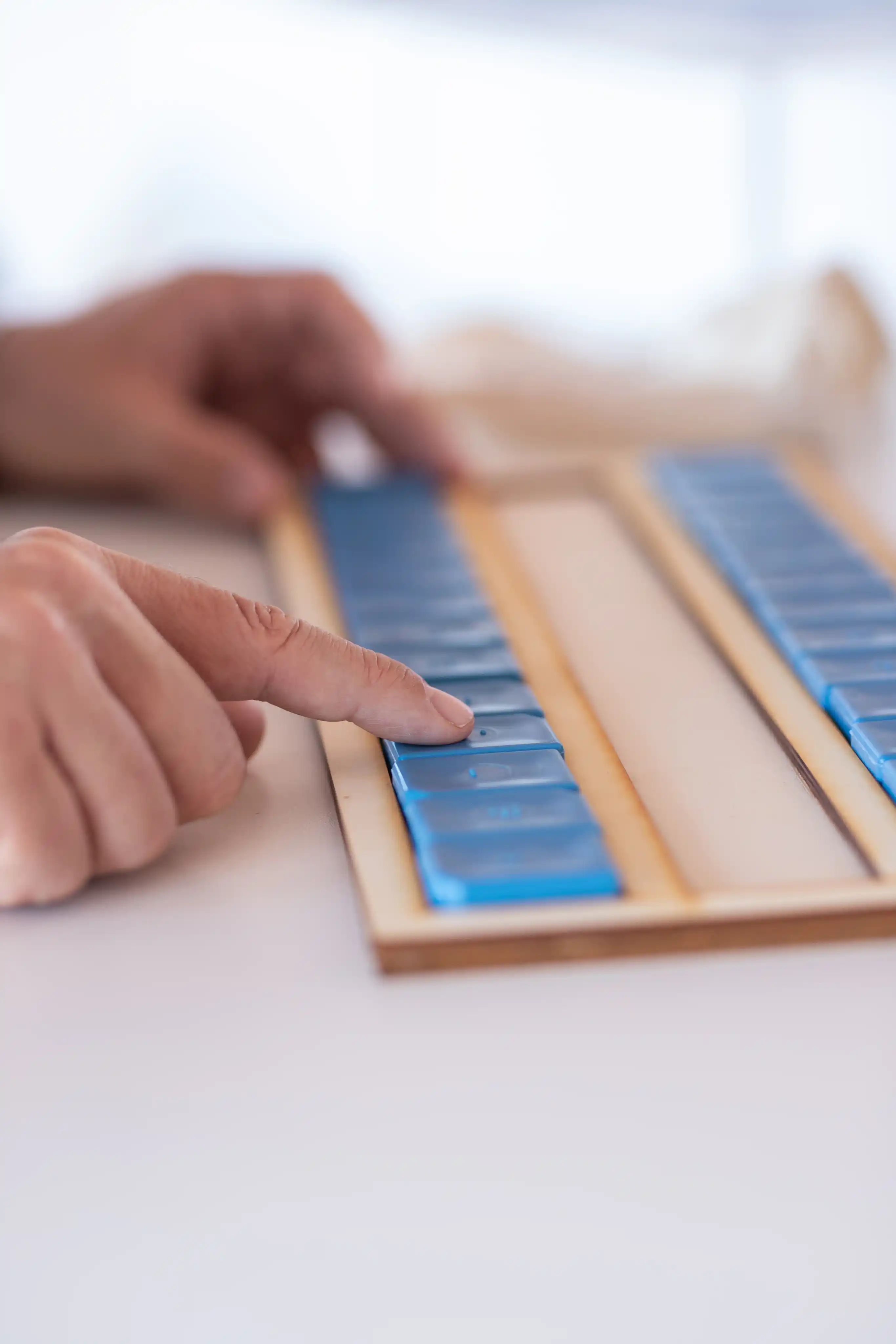Personne qui touche les dominos BR'EYE - Dispositif d'apprentissage scolaire adapté
